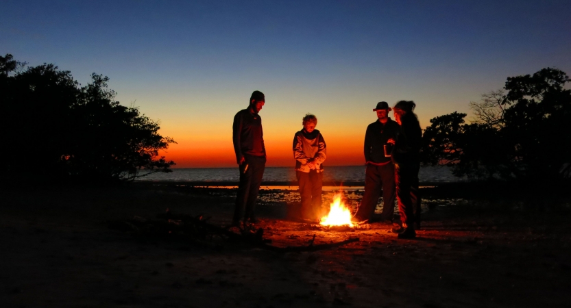 a group of veterans stand around a fire on an outward bound veterans expedition 